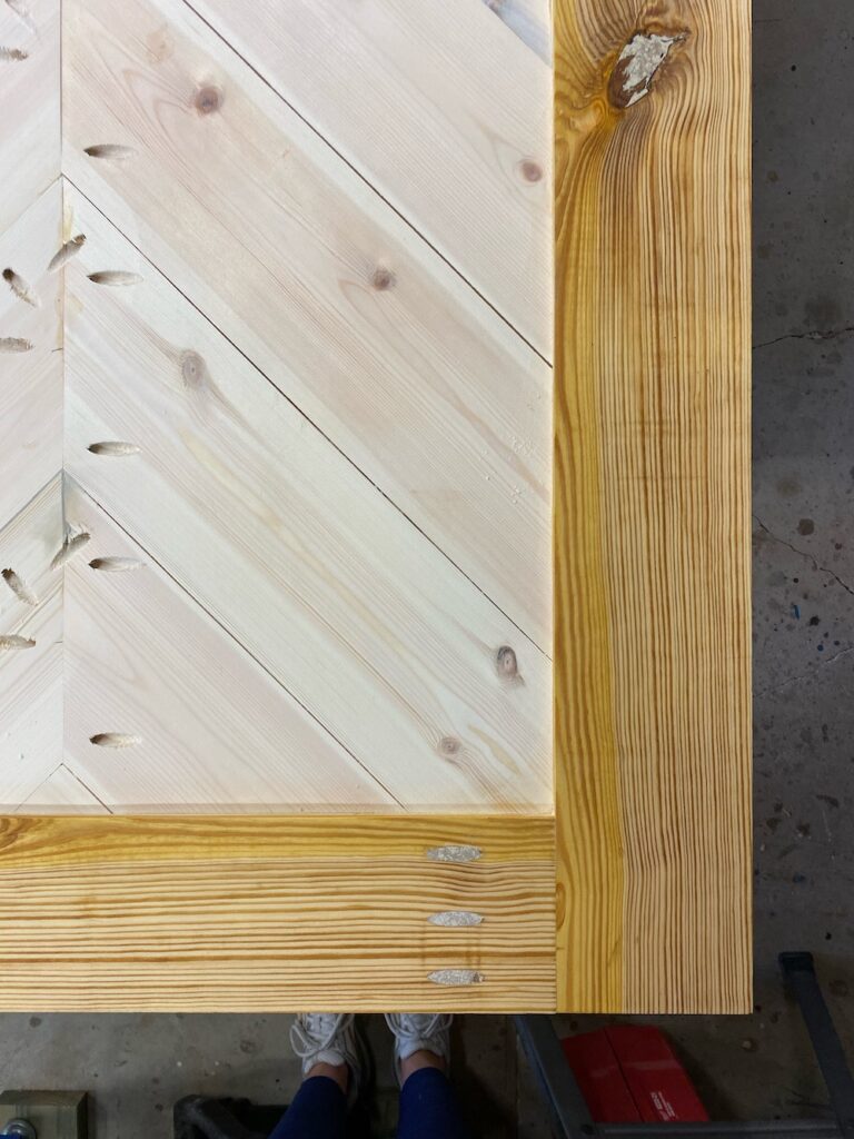 Close up of corner of an unfinished barn door during bleaching process.