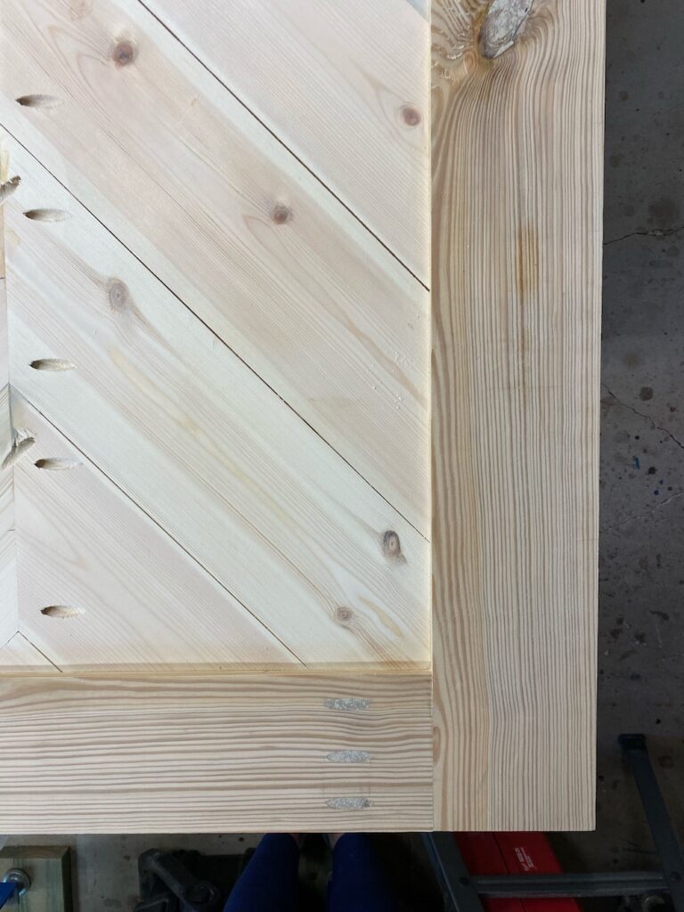Close up of corner of an unfinished barn door during bleaching process.