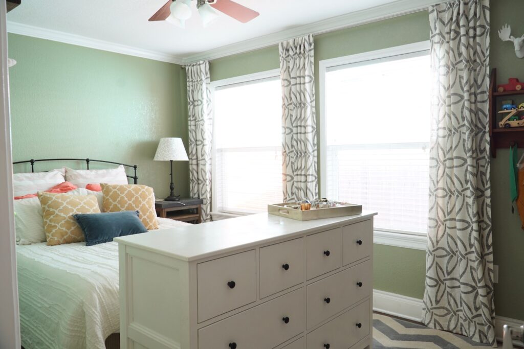Bedroom with a queen size bed and white 8 drawer dresser..