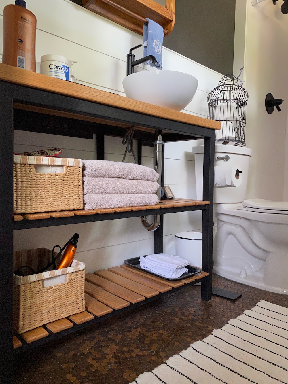 Small bathroom with white shiplap walls, and modern industrial vanity.